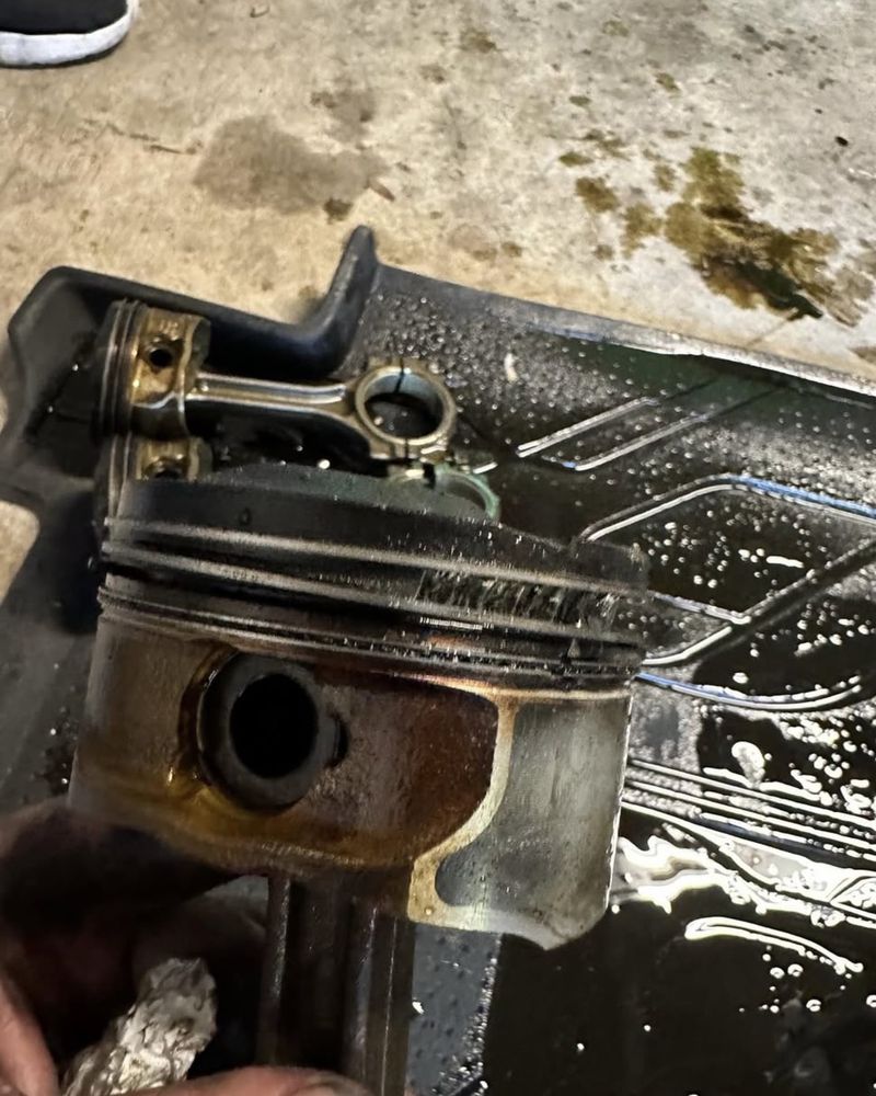 An original piston from the LNF held up after teardown, its ring land visibly damaged