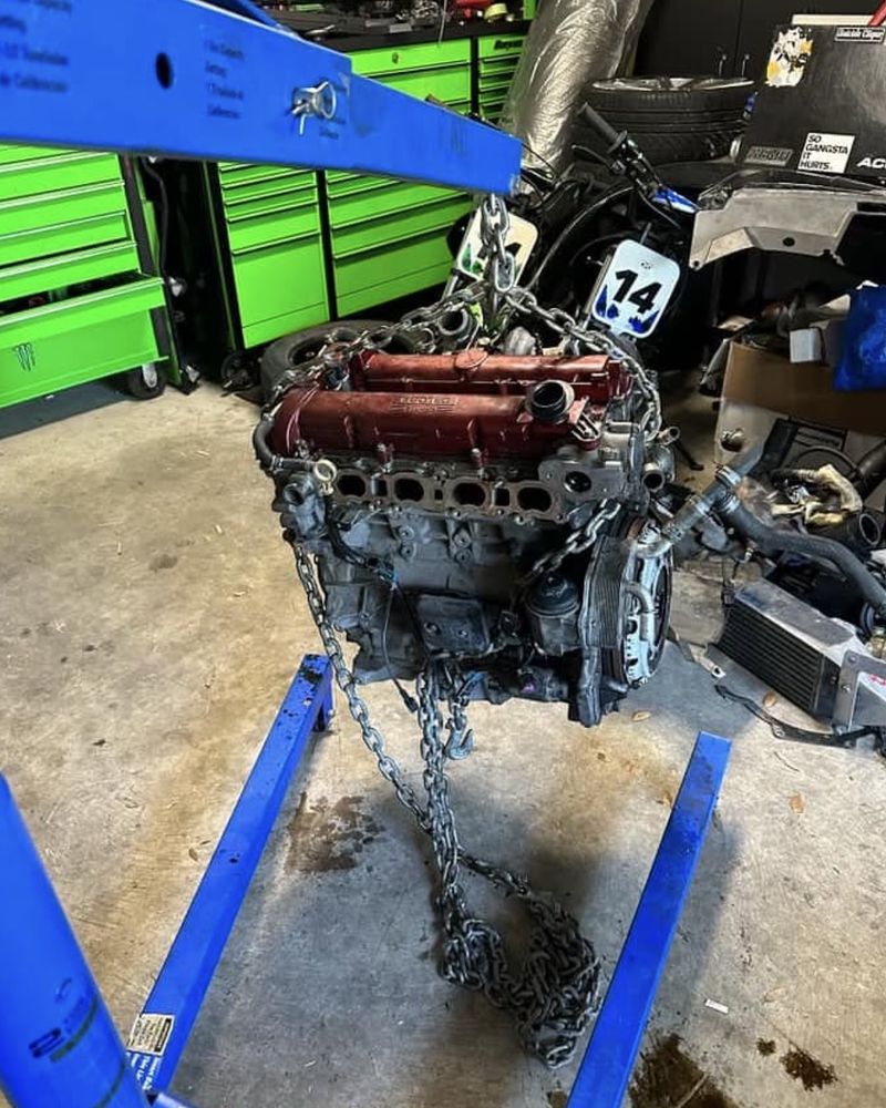 The LNF hanging from the hoist on its own, red cam cover up, in the garage