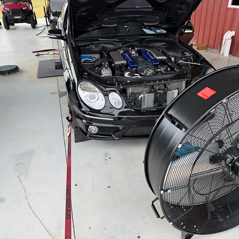 The supercharged V8 in the E55, hood up with the cooling fan set